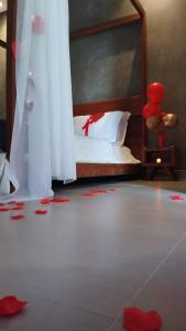 Pousada Vila do Lago في كابيتوليو: غرفة نوم مع سرير مع بتلات حمراء على الأرض