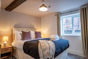 a bedroom with a large bed and a window at Guest Homes - Chandan Court Apartment in Bewdley