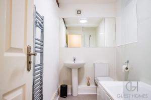 a white bathroom with a sink and a mirror at Host & Stay - Chandan Court Apartment in Bewdley