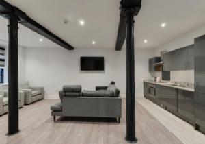 a living room with a couch and a kitchen at Temple Court Cavern Quarter Apartments in Liverpool