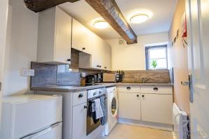 uma cozinha com máquina de lavar e secar roupa em Guest Homes - Chandan Court Apartment em Bewdley