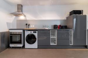 eine Küche mit einer Waschmaschine und einer Waschmaschine in der Unterkunft Tourcoing equipped apartment with terrace in Tourcoing