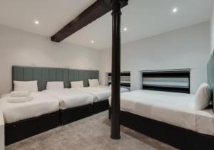 two beds in a room with white walls at Temple Court Cavern Quarter Apartments in Liverpool