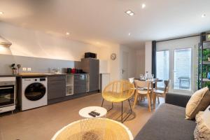 eine Küche und ein Wohnzimmer mit einem Sofa und einem Tisch in der Unterkunft Tourcoing equipped apartment with terrace in Tourcoing