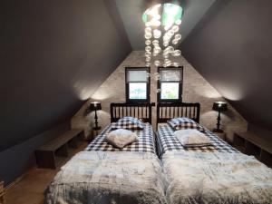 2 camas num quarto no sótão com um lustre em La Buissonnière em Veulettes-sur-Mer