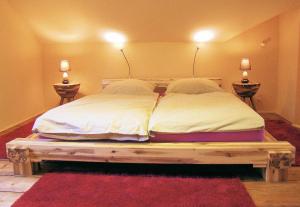 a bedroom with a large bed with two lamps on the wall at Altes Backhaus in Bad Harzburg