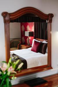 1 dormitorio con 1 cama con marco de madera en Brackenborough Hotel en Louth