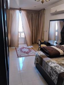 a bedroom with a bed and a desk in it at شقة راقية مطلة علي كورنيش النيل المعادي - عوائل فقط in Cairo