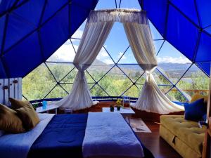 a room with a bed and a large window at Glamping blue. in Guatavita