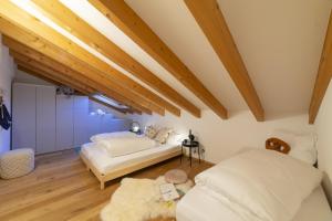 - 2 lits dans une chambre dotée de plafonds en bois dans l'établissement Gamsalpblick, à Wildhaus