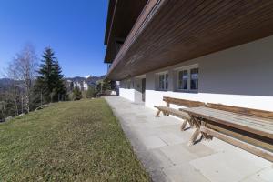 a wooden bench sitting outside of a building at Gamsalpblick in Wildhaus