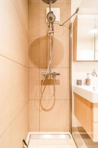 a shower with a glass door next to a sink at Beautiful apartment in the city and free parking in Luxembourg