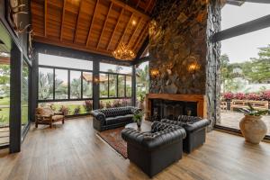 a living room with leather furniture and a stone fireplace at LAS HOTEL BOUTIQUE in Foz do Iguaçu