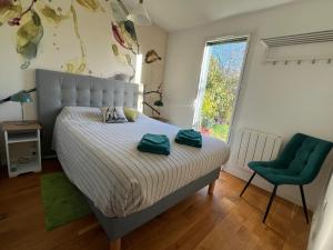 ein Schlafzimmer mit einem Bett und einem grünen Stuhl in der Unterkunft LA PATTE D'OURS 2 in Ambon