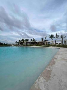a large pool of blue water with palm trees at sunrise-villa-at-vistacana in Punta Cana