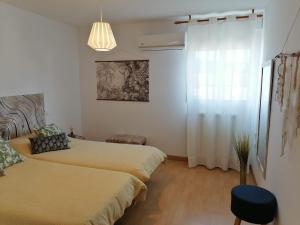 um quarto com 2 camas e um lustre em El Vergel del Piedra em Munébrega