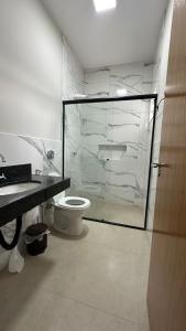 een badkamer met een glazen douche en een toilet bij Casa Alissa in Bonito
