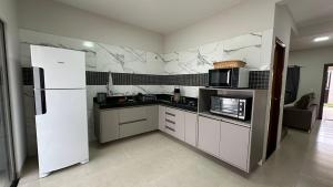 een keuken met witte apparatuur en een witte koelkast bij Casa Alissa in Bonito