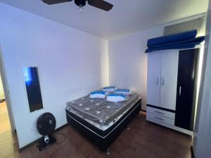 a bedroom with a bed with blue pillows on it at Apartamento 106 in Cabo Frio