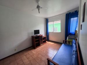 a living room with a couch and a tv and a window at Apartamento 106 in Cabo Frio