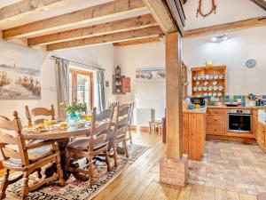 a kitchen and dining room with a wooden table and chairs at 3 bed property in Tatterset 75673 in Tattersett