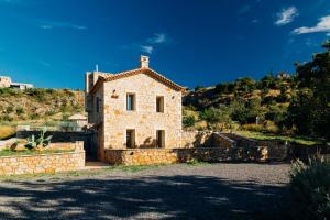 a stone house on a hill with a blue sky at Gea Mani Villas in Agios Nikolaos