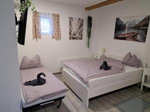 two black swans sitting on beds in a bedroom at Maja Vendégház in Dunaalmás