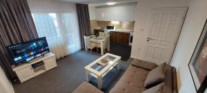 een woonkamer met een bank en een tv en een keuken bij VILLA HIPODROM ilidza apartments in Sarajevo