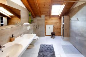 a bathroom with a sink and a toilet and a tub at MyWinkl Design-Ferienwohnungen in Reit im Winkl