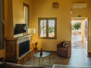 a living room with a tv and a couch and a table at Gea Mani Villas in Agios Nikolaos