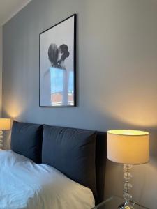 a bedroom with a bed and a picture on the wall at Bilocale moderno - Lorenteggio 145 in Milan