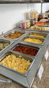 a buffet of different types of food in trays at EL SHADDAI HOTEL in João Pessoa
