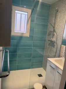 a bathroom with a shower and a toilet and a window at Patrimoine et immobilier Villas du Lac in Soustons