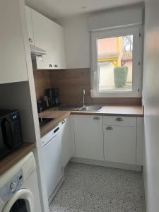 a small kitchen with a sink and a window at Patrimoine et immobilier Villas du Lac in Soustons