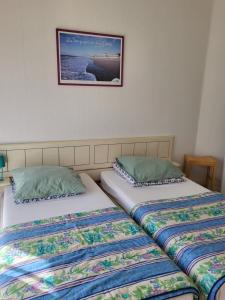 twee bedden naast elkaar in een kamer bij Résidence Rose des Vents in Jullouville-les-Pins