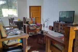ein Wohnzimmer mit einem Flachbild-TV und Möbeln in der Unterkunft Casa com piscina no interior em condomínio fechado in Quadra