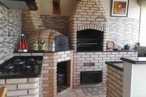 a brick oven with a stove in a kitchen at Casa com piscina no interior em condomínio fechado in Quadra