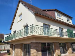 a house with a balcony on top of it at Résidence Rose des Vents in Jullouville-les-Pins