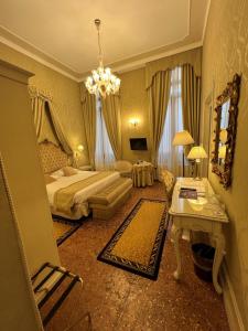 a bedroom with a bed and a chandelier at Hotel Al Duca Di Venezia in Venice