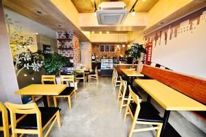 ein Restaurant mit Holztischen und -stühlen in einem Zimmer in der Unterkunft Gyeongju Namu Guesthouse in Gyeongju