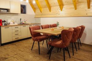 a kitchen with a wooden table and chairs at Vila Marija HP in Han Pijesak