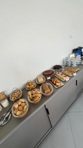 a counter with a bunch of different types of pastries at EL SHADDAI HOTEL in João Pessoa