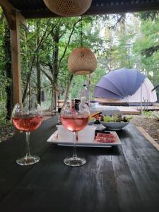 a table with two glasses of wine on it at OUT & LODGE, Wigwam in Couvin