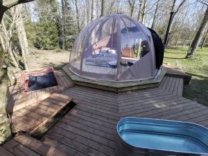 OUT & LODGE, Wigwam في كوفين: خيمة قبة مع حوض استحمام ساخن على سطح خشبي
