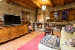 a living room with a television and a fireplace at Casa Rural Anita in Cabrillanes