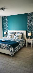 um quarto com uma cama e uma parede azul em "Notre Bastide" Maison et table d'hôtes sur réservation, Piscine, Climatisation, Jacuzzi em Marcillac-Saint-Quentin