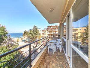 a balcony with tables and chairs and a view of the ocean at Relax Larrisa Studio in Primorsko