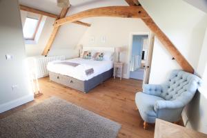 um quarto com uma cama e uma cadeira num quarto em An 8 Bed Luxury Farmhouse 
