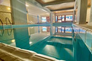 an indoor swimming pool with blue water at Pool and Sauna! San Bernardino 3-Bedroom Apartment with Free Parking! in San Bernardino