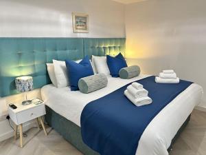 a bedroom with a large bed with blue and white pillows at Lobster House - Newquay Cornwall in Newquay